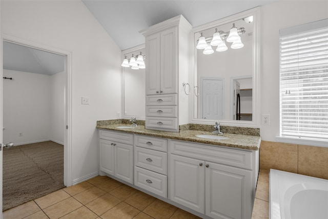 bathroom featuring tile patterned flooring, vanity, plenty of natural light, and lofted ceiling