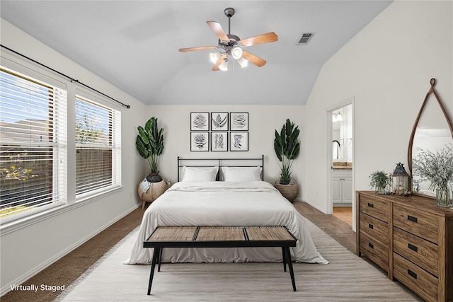 bedroom featuring ensuite bathroom, ceiling fan, lofted ceiling, and light carpet