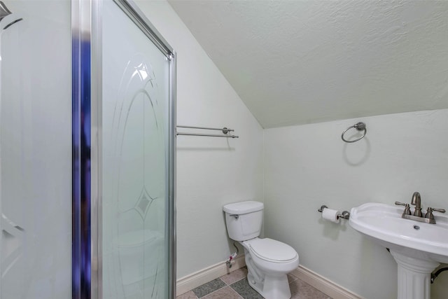 bathroom featuring lofted ceiling, a shower with door, toilet, and sink