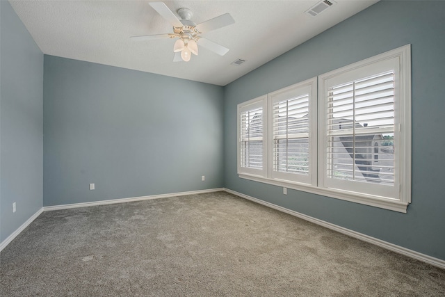 empty room with a textured ceiling, carpet, and ceiling fan