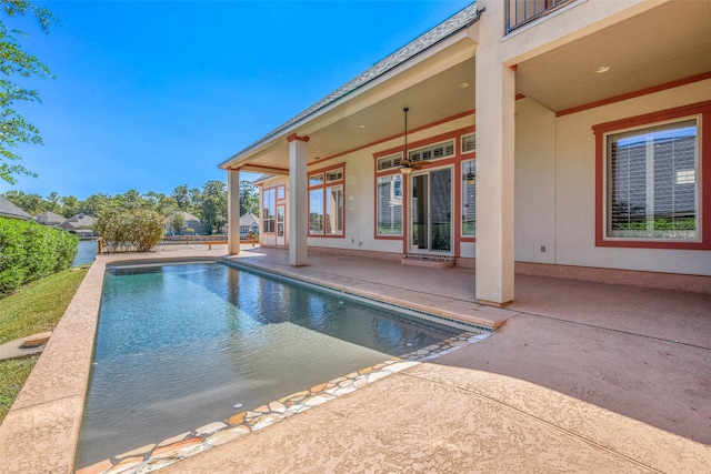 view of swimming pool featuring ceiling fan and a patio