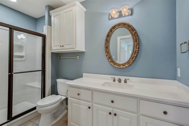 bathroom with vanity, a shower with shower door, toilet, and tile patterned floors