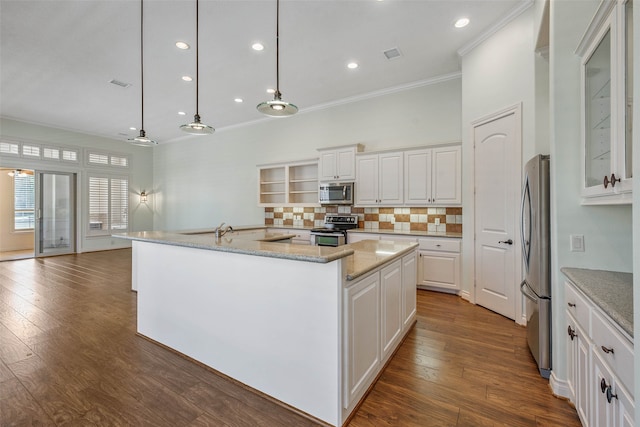 kitchen with stainless steel appliances, white cabinetry, a center island with sink, and hardwood / wood-style floors