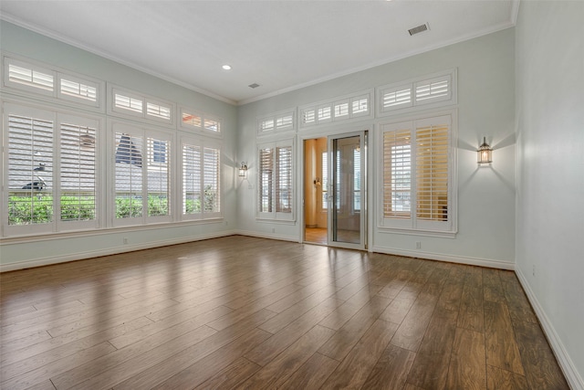 empty room with crown molding and dark hardwood / wood-style flooring