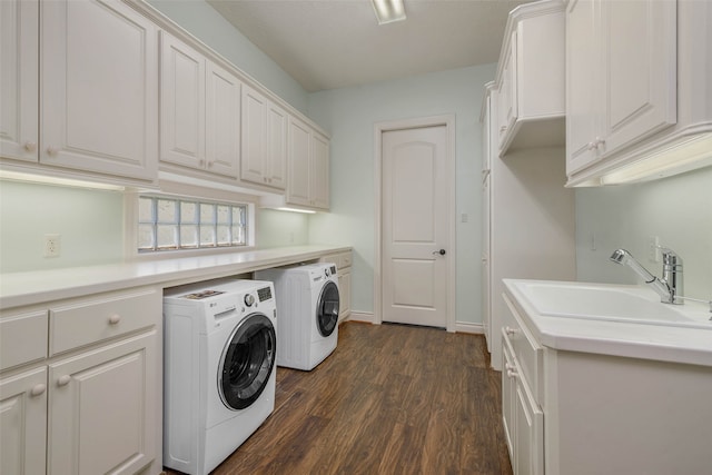 laundry area featuring dark hardwood / wood-style flooring, independent washer and dryer, sink, and cabinets