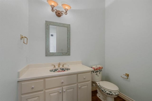 bathroom with vanity, toilet, and hardwood / wood-style flooring