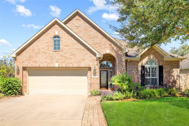 view of property featuring a garage and a front lawn