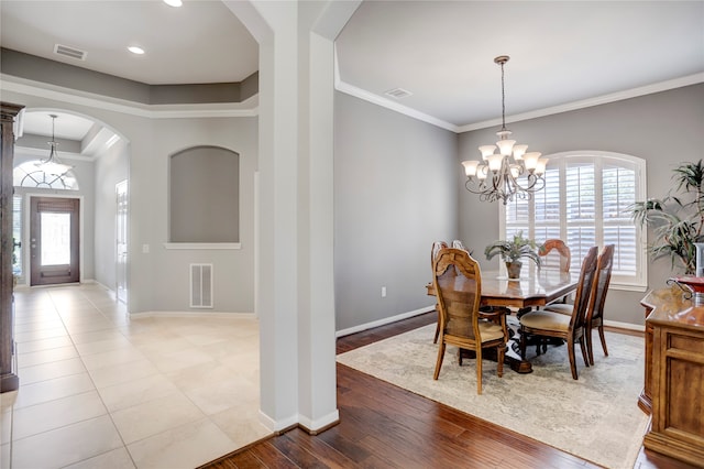 dining room featuring light hardwood / wood-style flooring, ornamental molding, and a notable chandelier