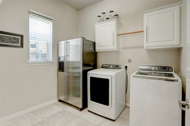 laundry room featuring cabinets, washer and clothes dryer, and light tile patterned floors