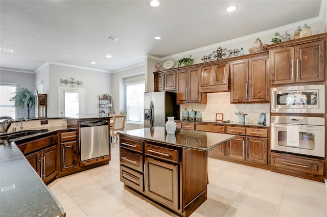 kitchen featuring ornamental molding, sink, a center island, and stainless steel appliances