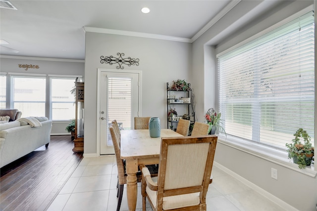 tiled dining room with crown molding and a wealth of natural light