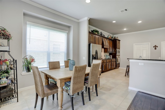 dining room featuring crown molding and light tile patterned flooring