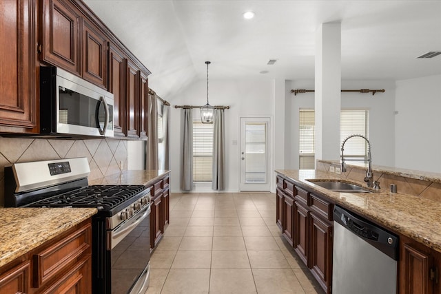 kitchen featuring light tile patterned floors, stainless steel appliances, lofted ceiling, light stone counters, and sink