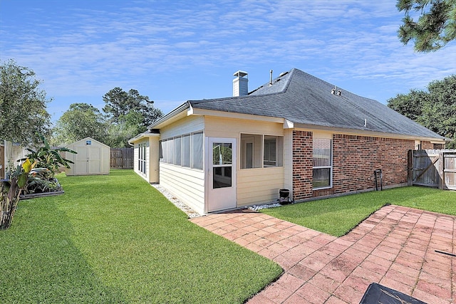 back of property with a patio area, a yard, and a storage unit