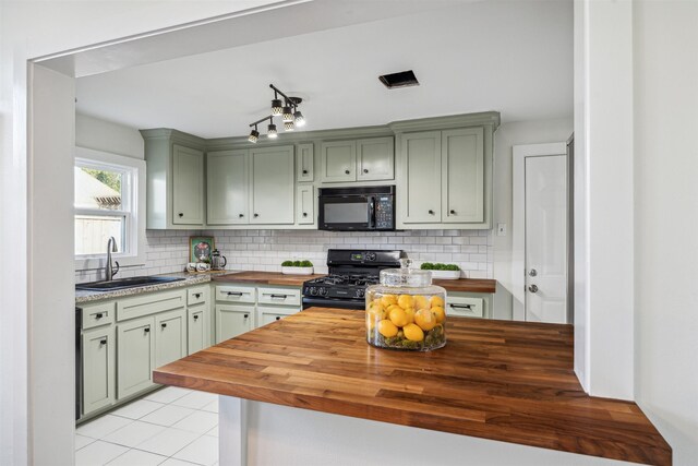 kitchen featuring tasteful backsplash, a sink, wooden counters, and black appliances