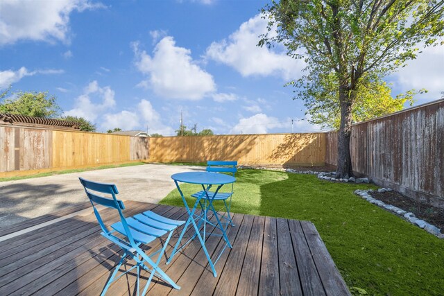 deck with a fenced backyard and a lawn