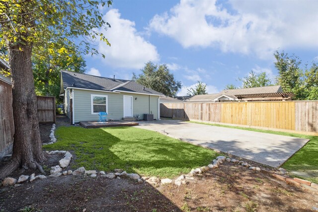 back of property with a fenced backyard, central AC, a lawn, and a patio