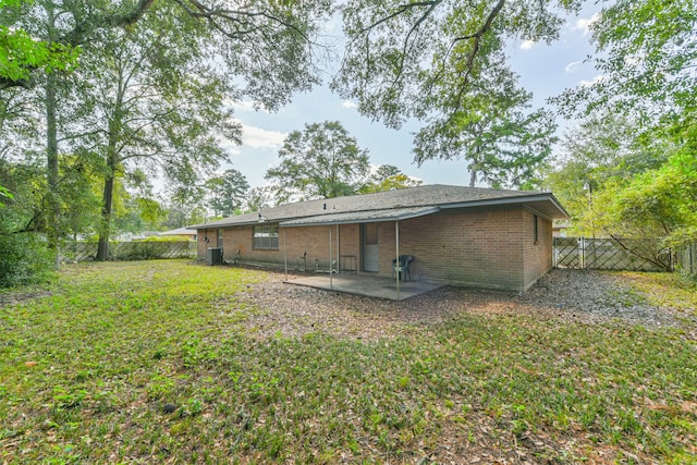 rear view of property featuring a lawn, a patio area, and central air condition unit