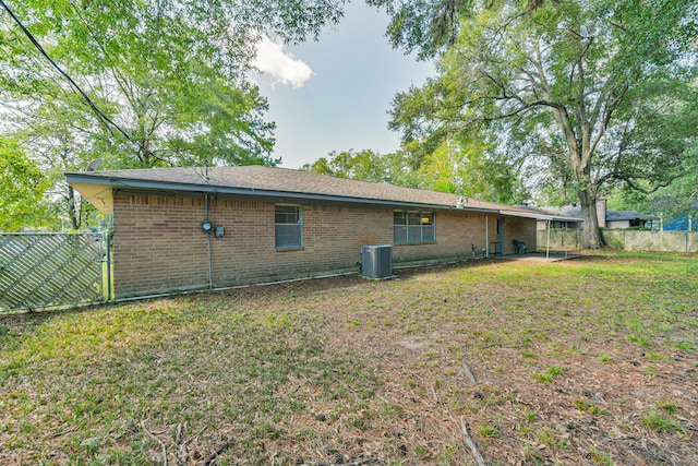 back of property featuring a yard and central air condition unit