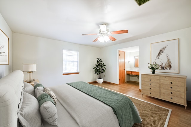 bedroom with ceiling fan, light hardwood / wood-style flooring, and ensuite bathroom