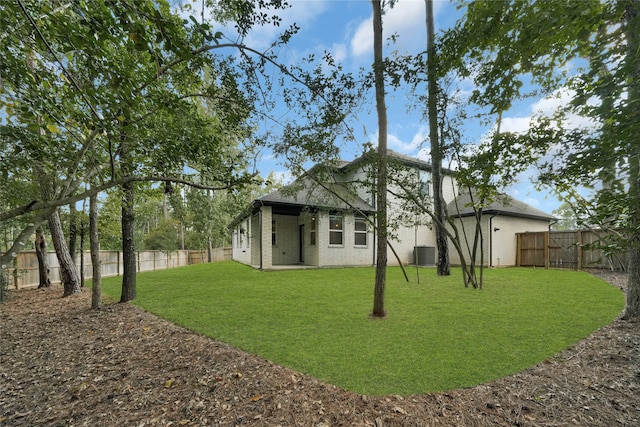 rear view of house with a yard and central AC unit