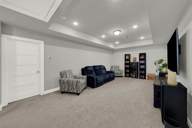 carpeted living room with a raised ceiling