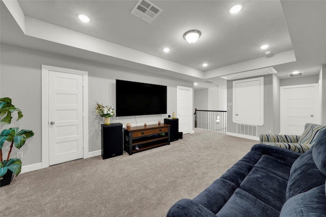 living room with carpet floors and a tray ceiling