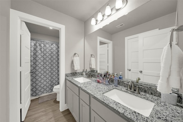 bathroom with a shower with curtain, hardwood / wood-style floors, vanity, and toilet