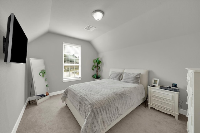 bedroom with light colored carpet and lofted ceiling