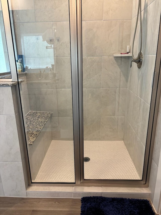 bathroom featuring hardwood / wood-style flooring and a shower with door