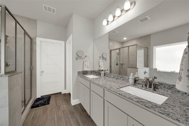 bathroom featuring vanity, an enclosed shower, and wood-type flooring