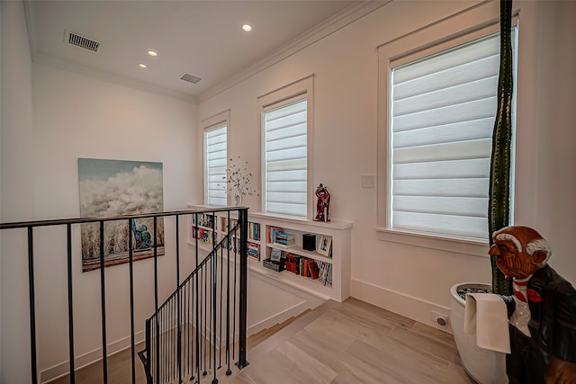 corridor with crown molding and light hardwood / wood-style flooring