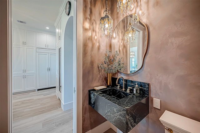 bathroom with toilet, wood-type flooring, and sink