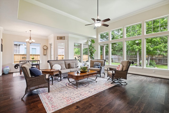 living area featuring ceiling fan with notable chandelier, plenty of natural light, and dark wood finished floors