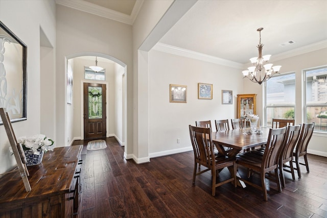 dining room with visible vents, arched walkways, dark wood-type flooring, crown molding, and a chandelier