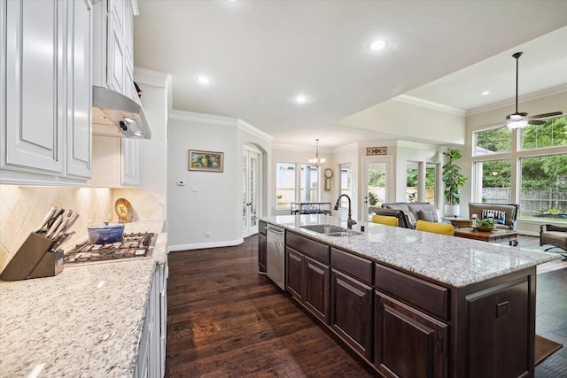 kitchen featuring a sink, baseboards, white cabinetry, under cabinet range hood, and appliances with stainless steel finishes