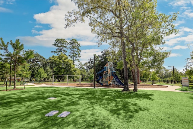 view of property's community with a playground and a yard