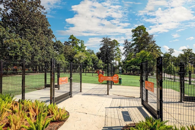 view of home's community with a gate, a lawn, and fence
