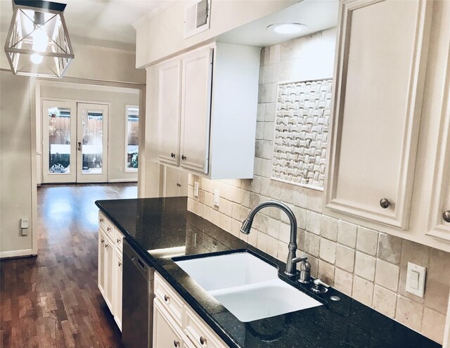 kitchen with sink, dark wood-type flooring, dishwasher, white cabinetry, and decorative light fixtures