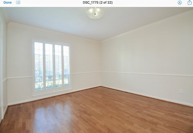 spare room with hardwood / wood-style floors and crown molding