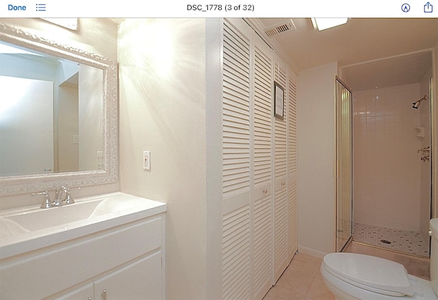 bathroom featuring an enclosed shower, vanity, tile patterned floors, and toilet