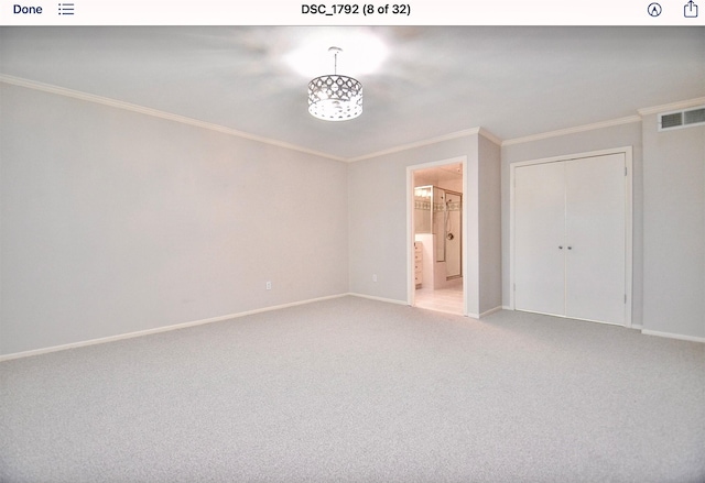 unfurnished bedroom featuring ornamental molding, carpet, ensuite bath, and a closet