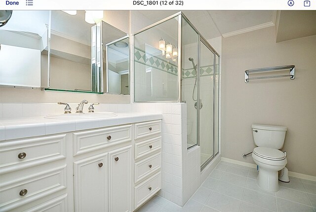 bathroom featuring a shower with shower door, ornamental molding, vanity, toilet, and tile patterned floors