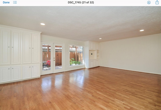 spare room featuring ceiling fan, light hardwood / wood-style flooring, and a textured ceiling