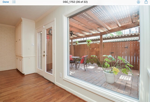 interior space featuring ornamental molding, brick wall, and hardwood / wood-style floors