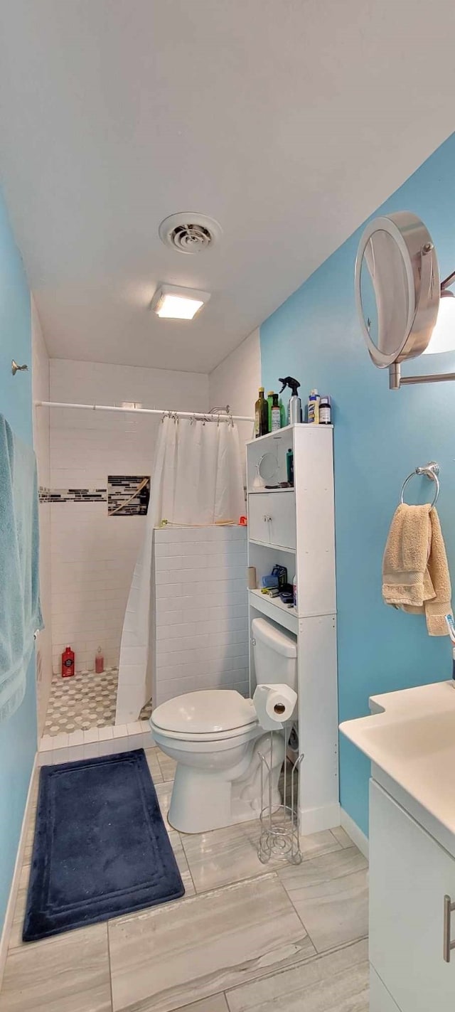 bathroom featuring walk in shower, vanity, and toilet