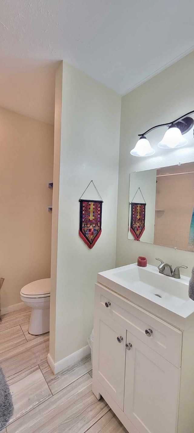 bathroom featuring wood-type flooring, vanity, and toilet