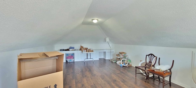 bonus room with a textured ceiling, lofted ceiling, and dark wood-type flooring