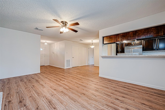 unfurnished living room featuring ceiling fan, a textured ceiling, and light hardwood / wood-style flooring