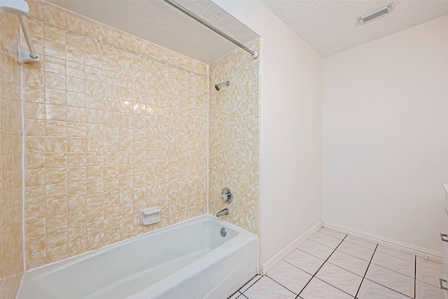 bathroom with tiled shower / bath combo, a textured ceiling, and tile patterned flooring